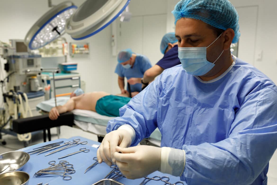 Dr. Ștefan Tucă, medic primar chirurg, verificând instrumentarul înaintea unei operații bariatrice într-o sală modernă de operație