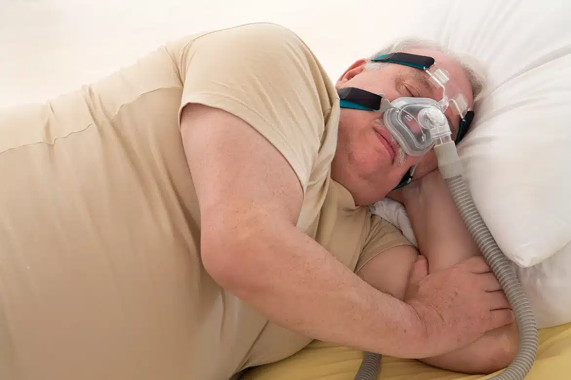 Bărbat cu apnee de somn care doarme cu mască CPAP