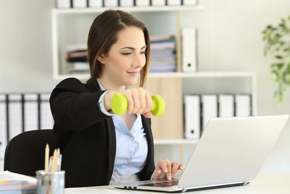 Reluarea activității după operația bariatrică – pacientă care efectuează exerciții ușoare la birou, semn al recuperării progresive după chirurgia bariatrică